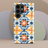 The Mediterranean Bloom for Samsung by Statement Cases features intricate, colorful floral patterns in blue, orange, and yellow. The design covers the entire back of the case, surrounding the camera cutout. Shock-absorbing and impact-resistant, it ensures protection while the brand "Statement Cases" is subtly printed near the bottom.